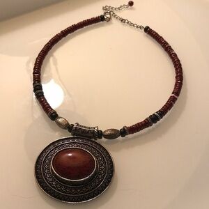 Necklace faux burgundy circular stone within silver carved silver pendant